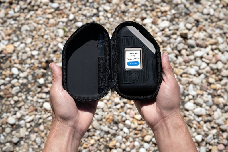 Hands holding the discreet carrying case for portable alcohol breathalyzer BI SoberTech.