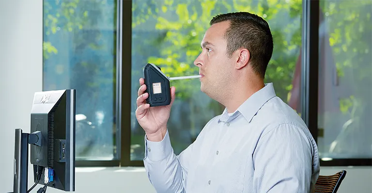 Man using a BI SL3, symbolizing the importance of effective drug and alcohol monitoring in community supervision.