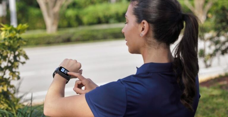Woman wears wrist-worn location tracking with proximity sensor and strap tamper detection as she checks the device for a message from her supervising officer.